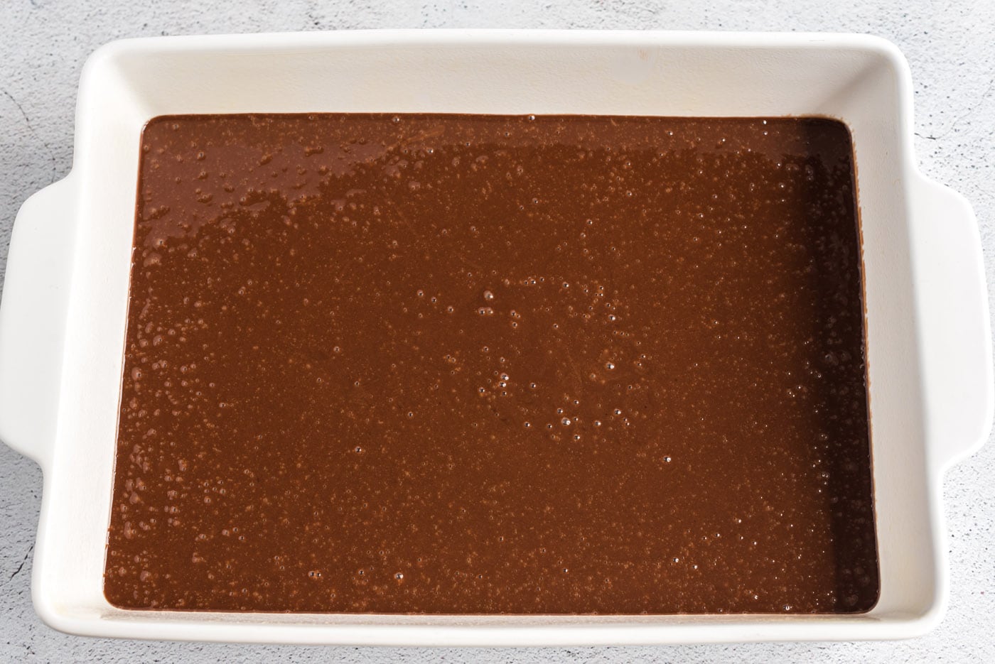 coca cola cake batter in a baking dish
