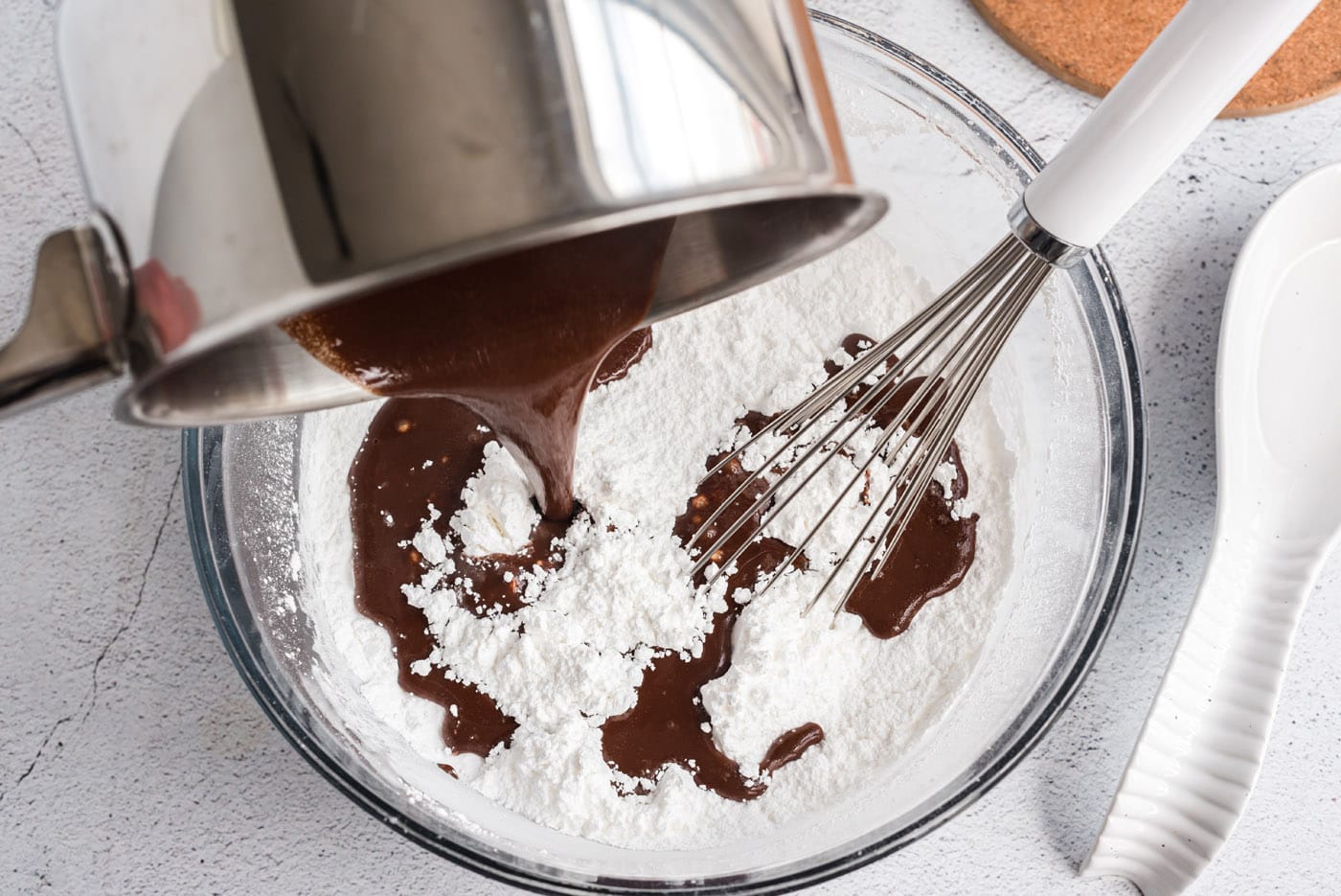 pouring melted chocolate mixture over powdered sugar