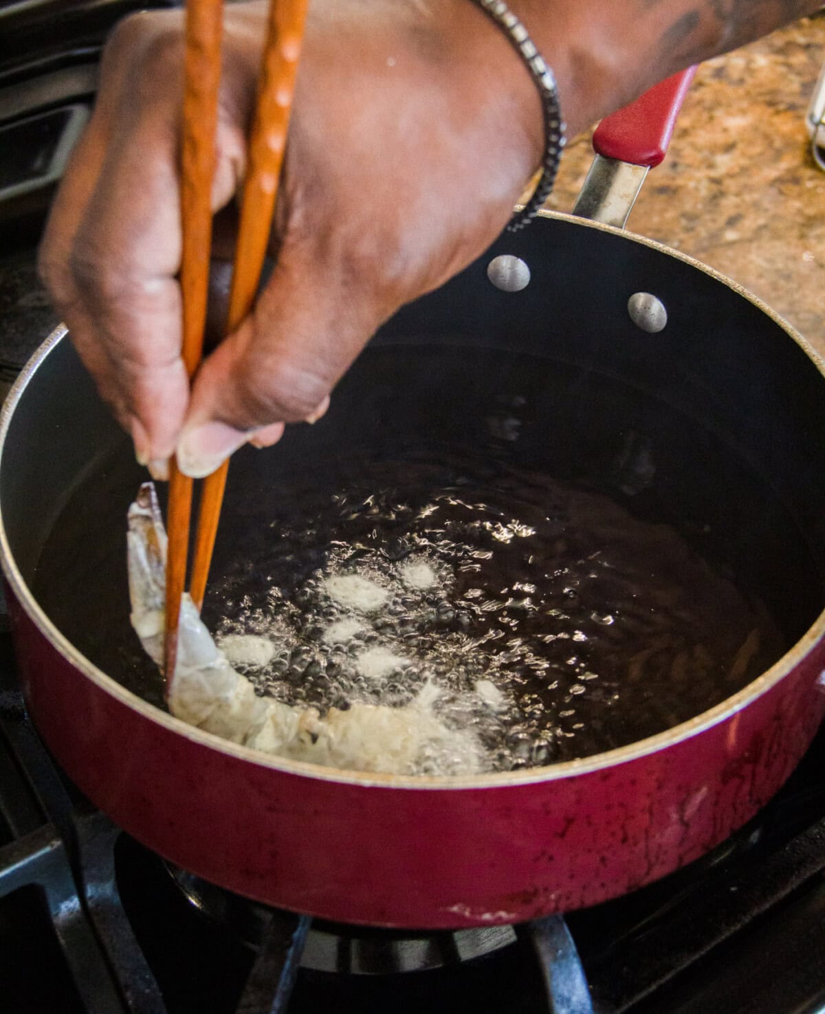 placing battered shrimp in a hot oil