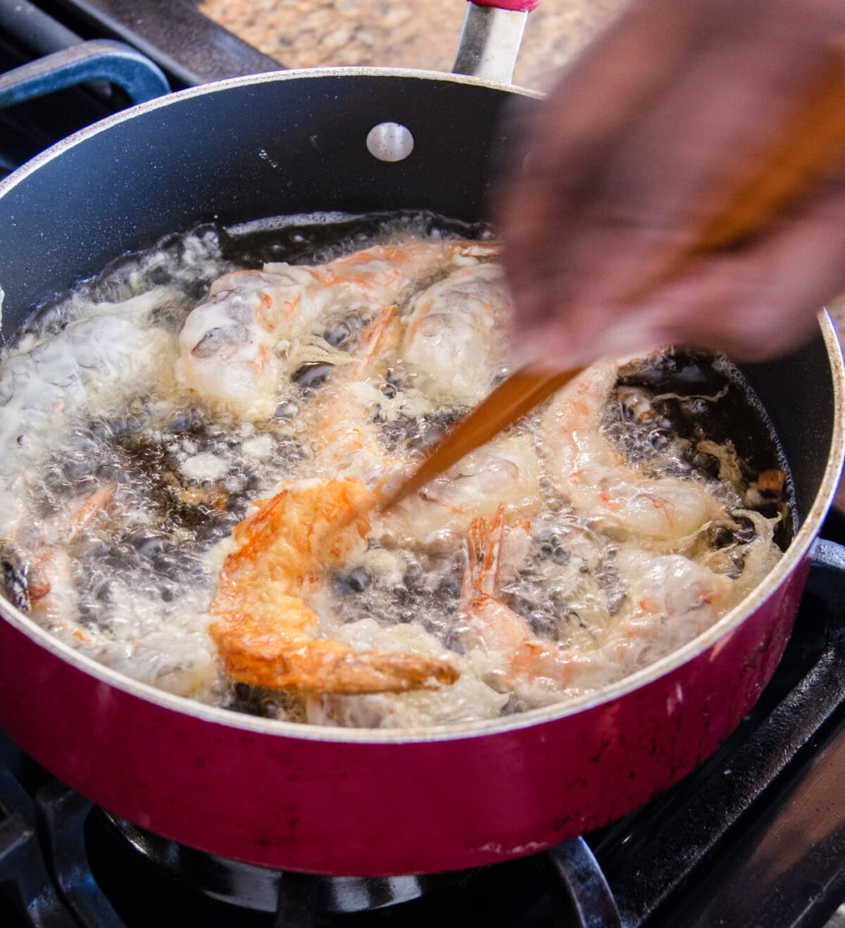 turning crispy fried shrimp in oil