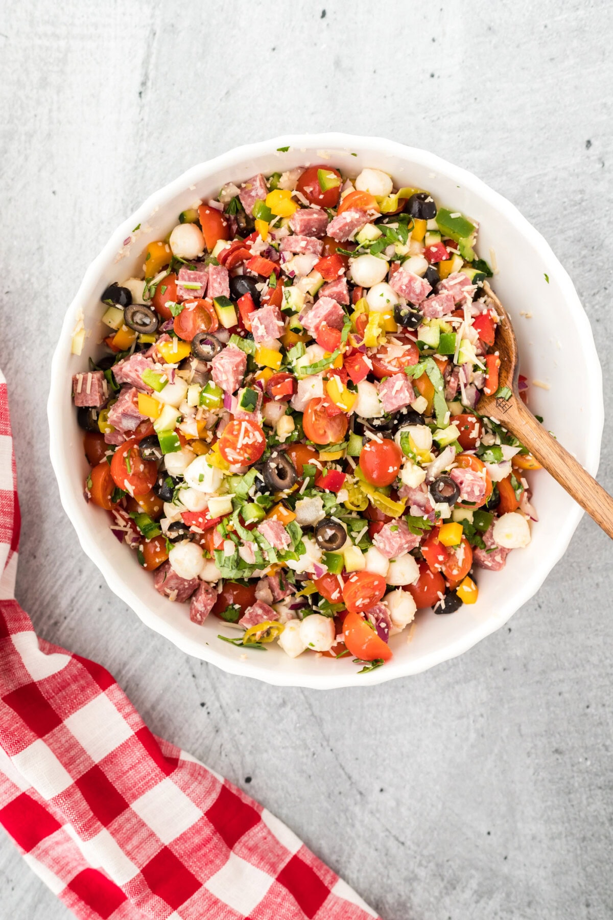 italian pasta salad veggies and meats mixed in a bowl