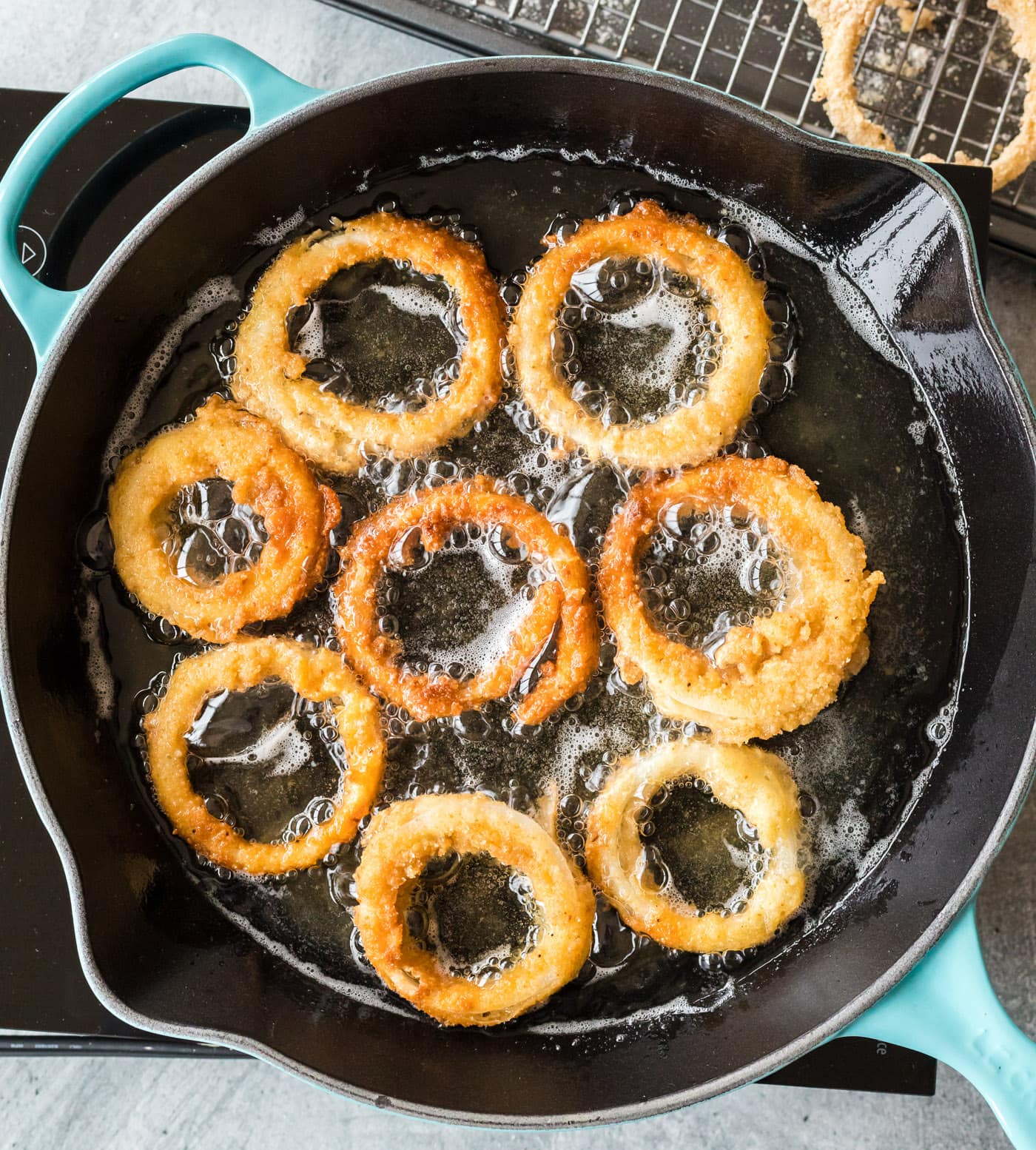 deep fried onion rings in a skillet