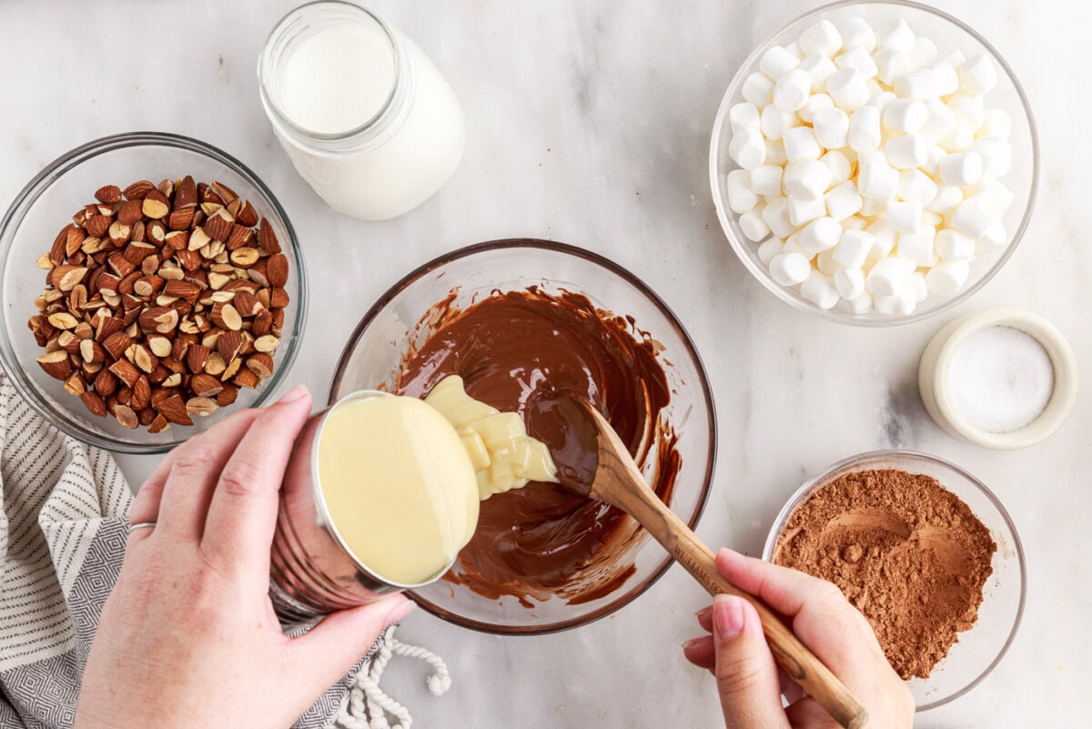 stirring sweetened condensed milk into melted chocolate