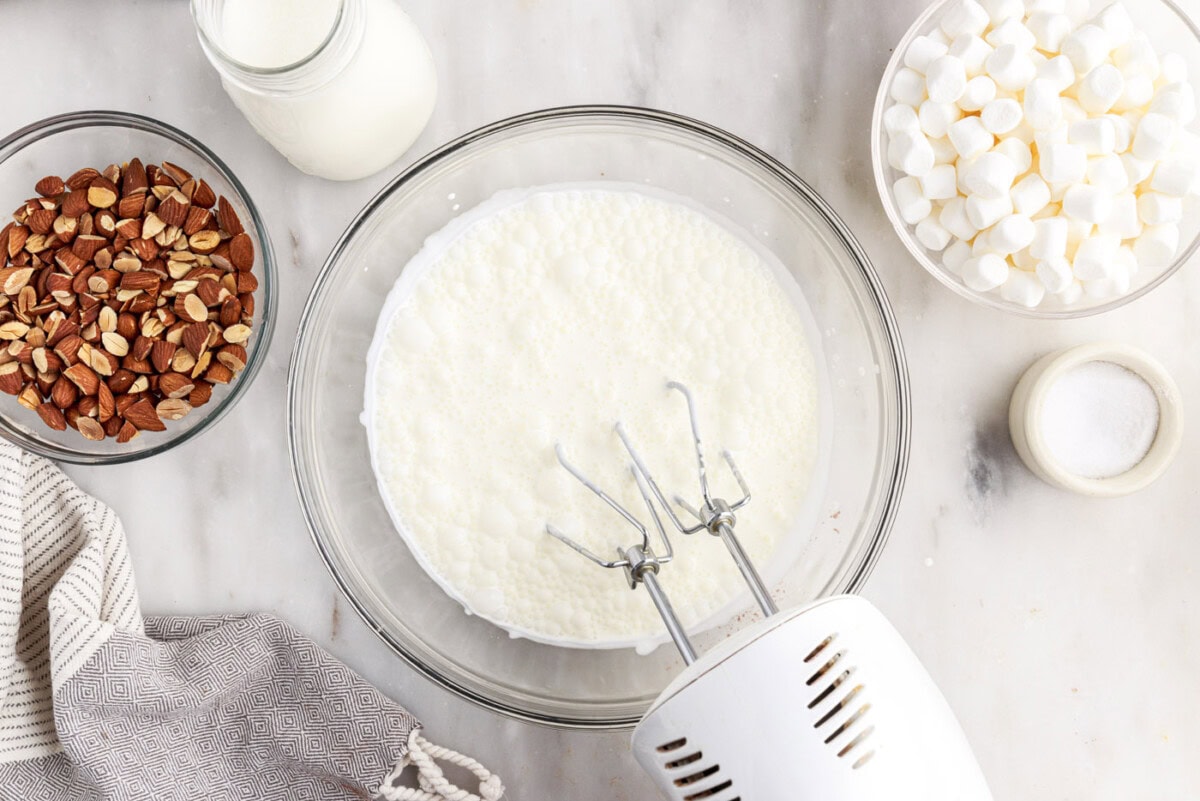 hand mixer whipping heavy cream in a bowl