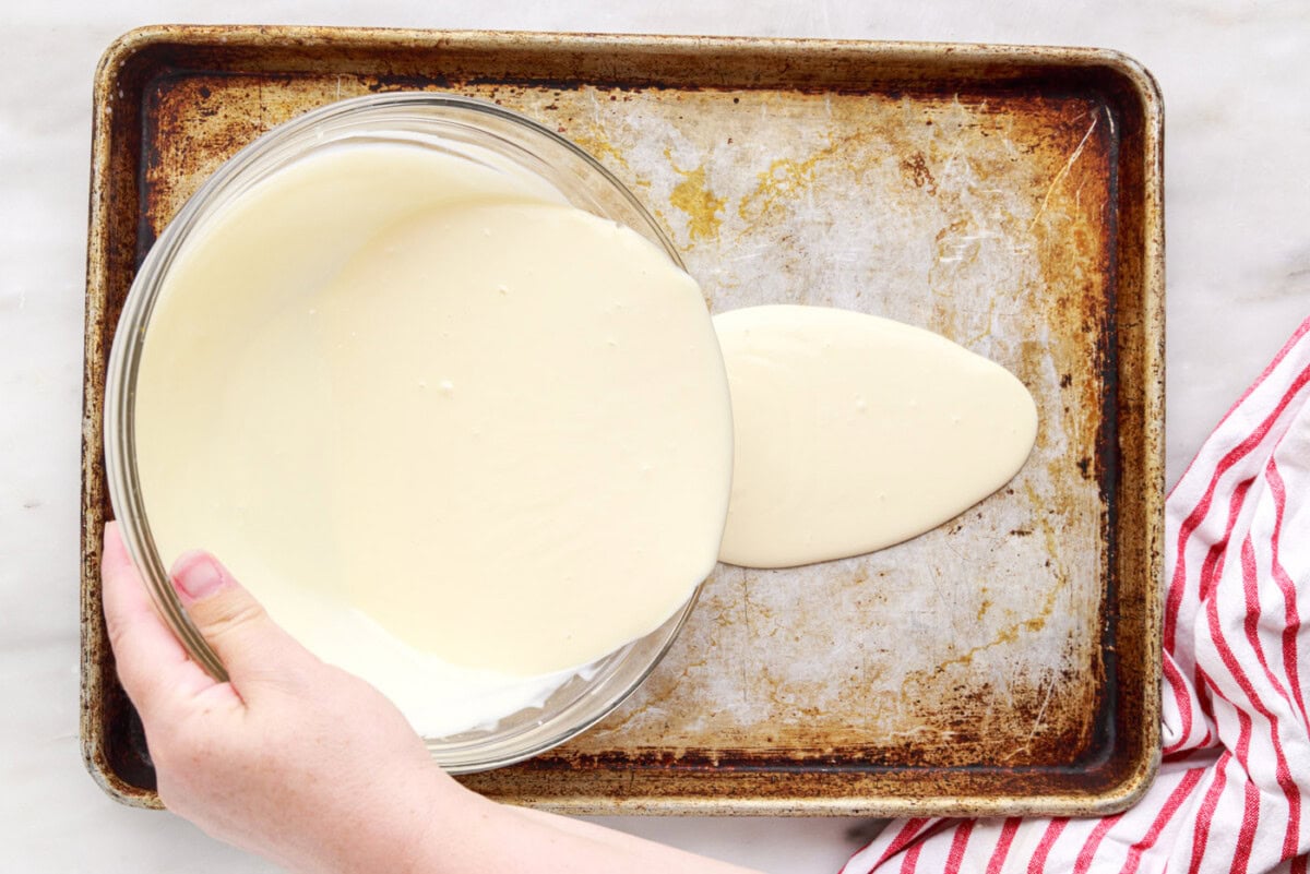pouring rolled ice cream ingredients into a pan