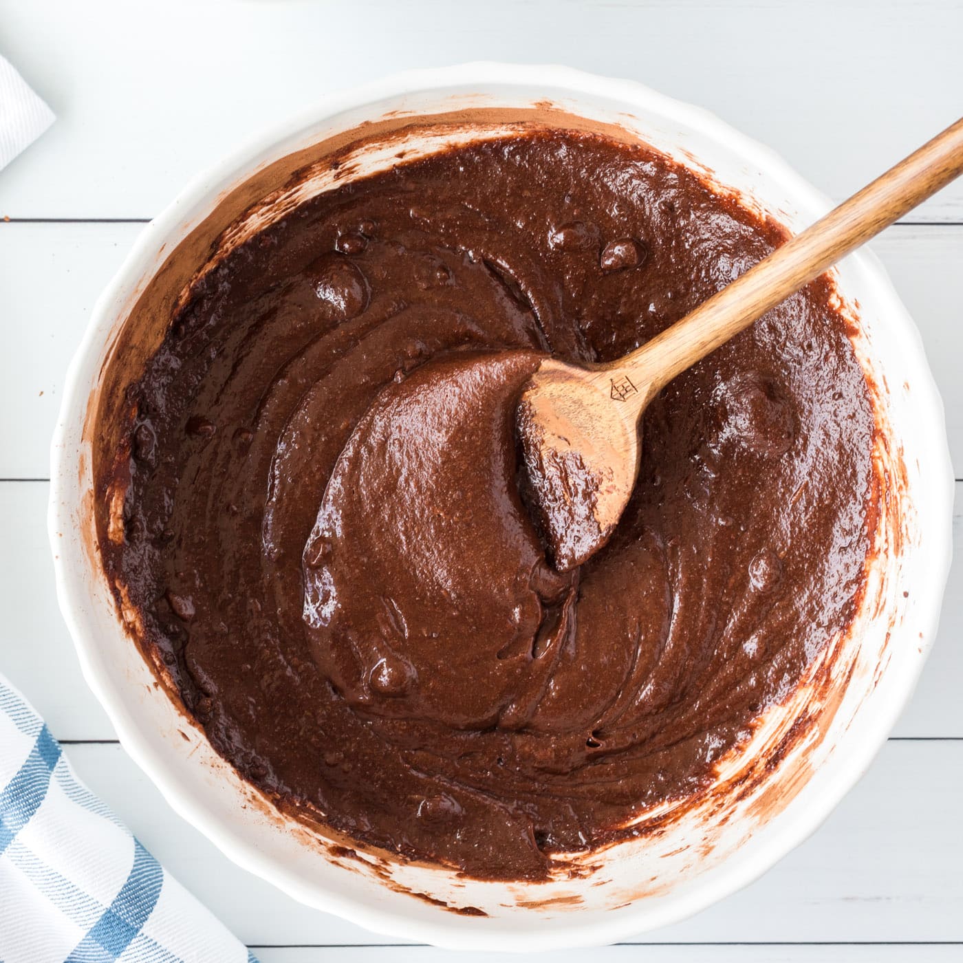 brownie batter in a bowl with wooden spoon