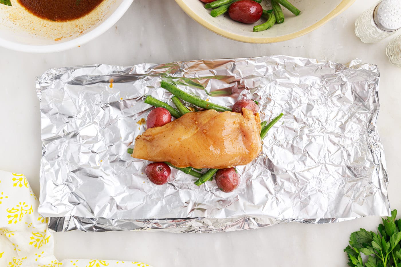chicken over green beans and potatoes in a foil packet
