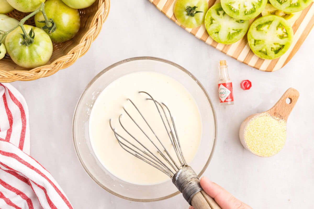 whisking buttermilk and egg in a bowl with tobasco