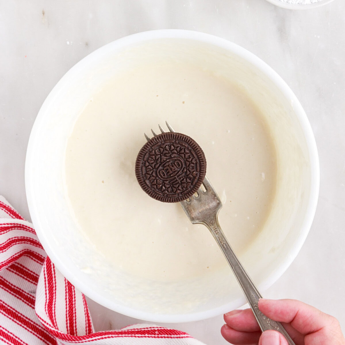 fork holding an oreo over pancake batter