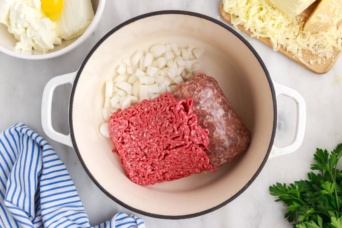 italian sausage and ground beef in a pan with onion