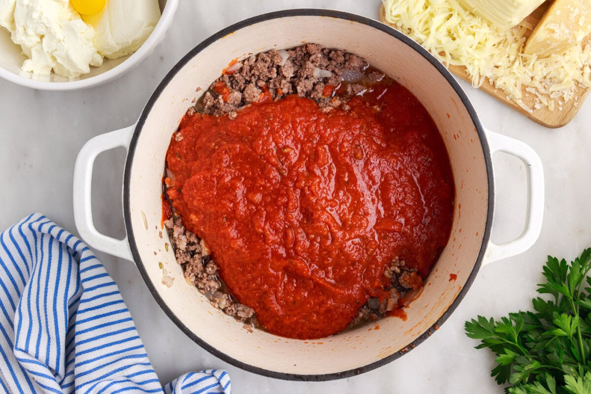 marinara sauce over cooked beef and sausage