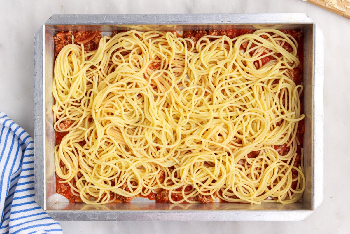 spaghetti over meat sauce in a pan