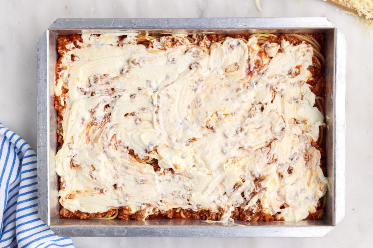 ricotta cheese mixture over meat sauce and spaghetti