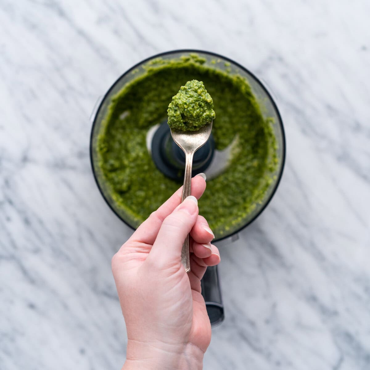 spoonful of pesto over food processor bowl