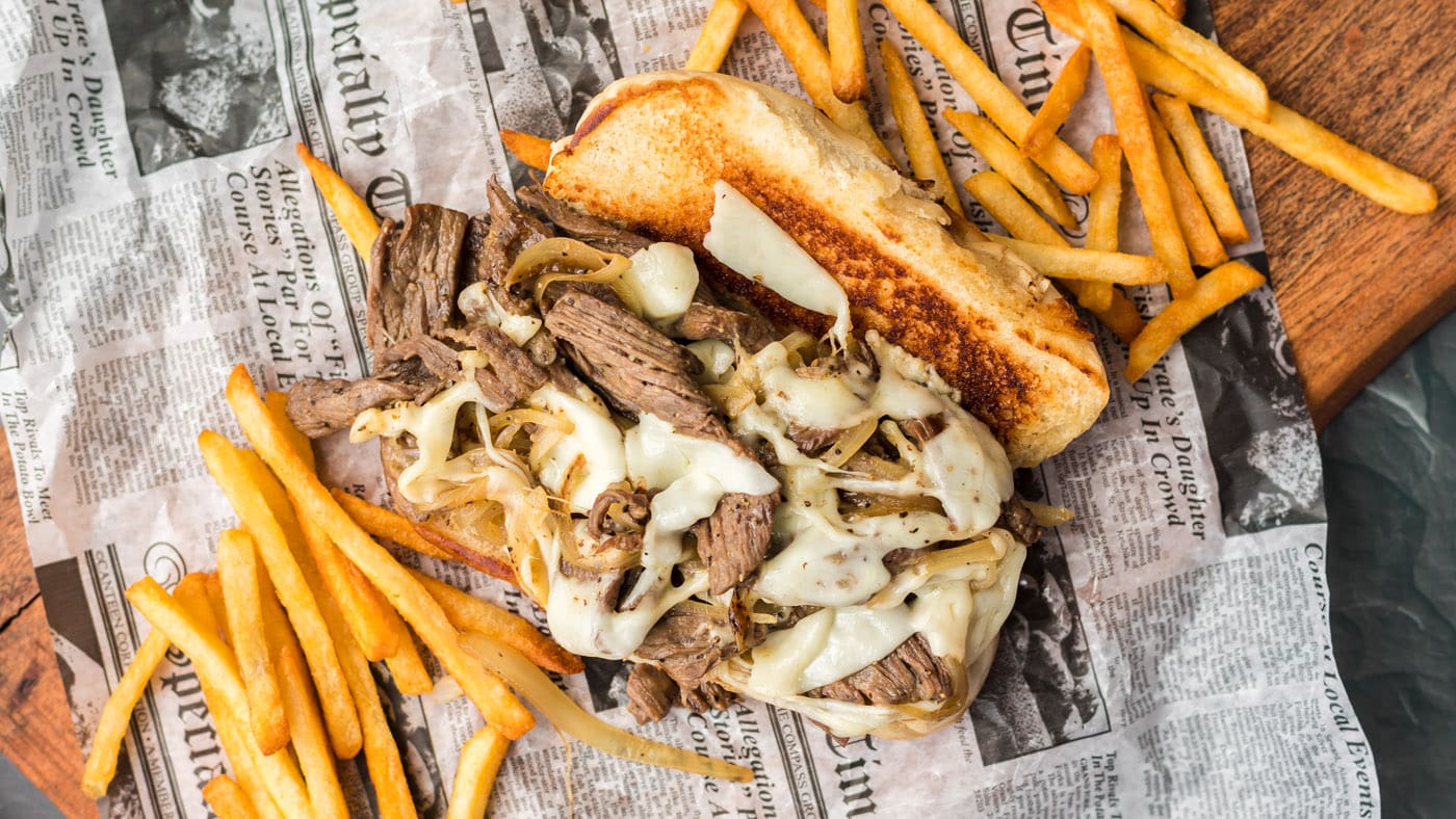 Tender strips of steak meet sauteed onions and provolone cheese in this Philly Cheesesteak sandwich.