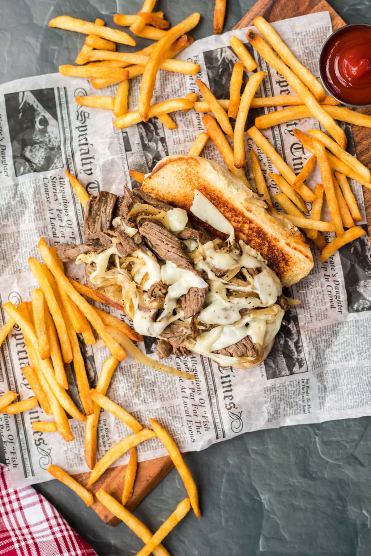 Philly Cheese Steak on parchment with fries