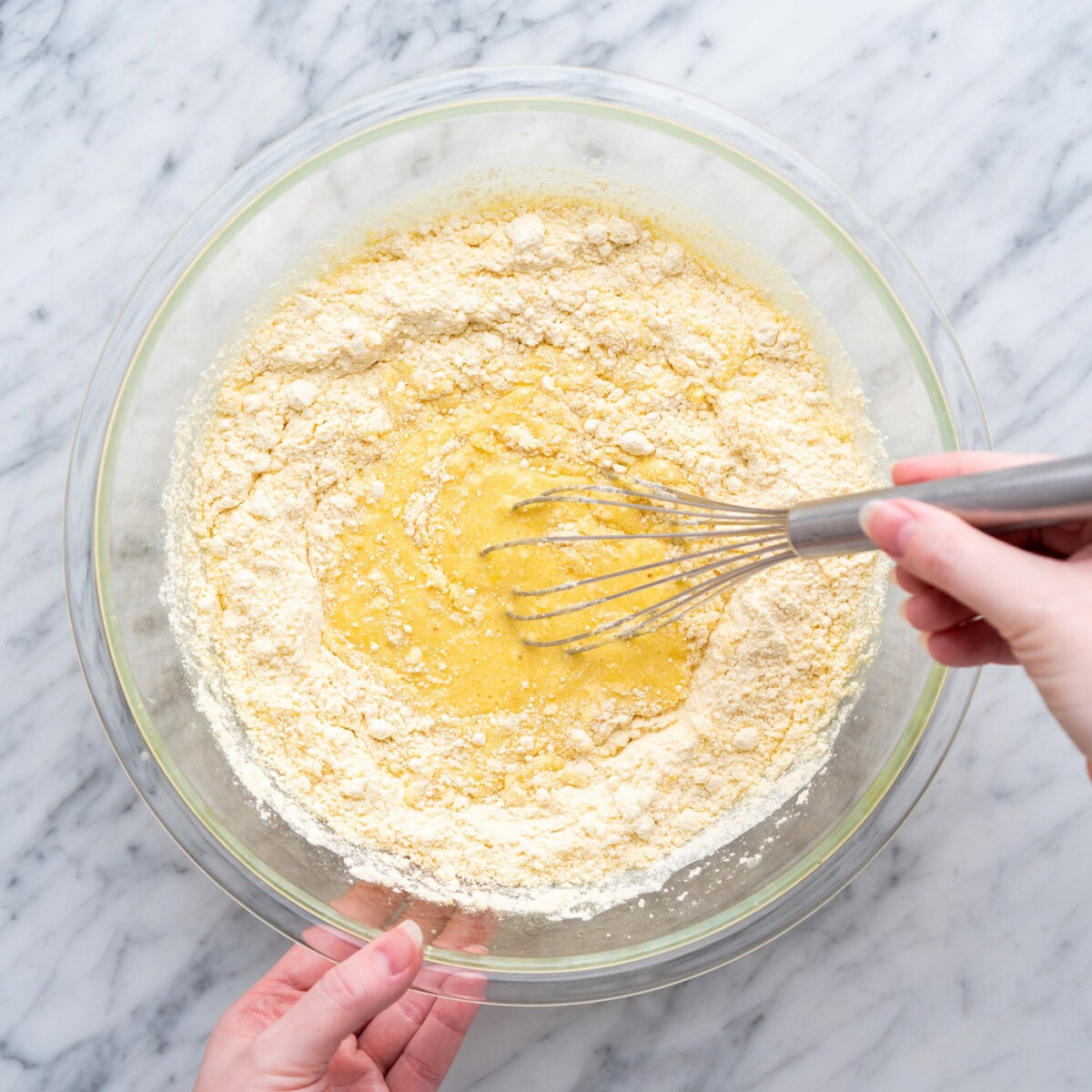whisking cake mix with crushed pineapple in a bowl