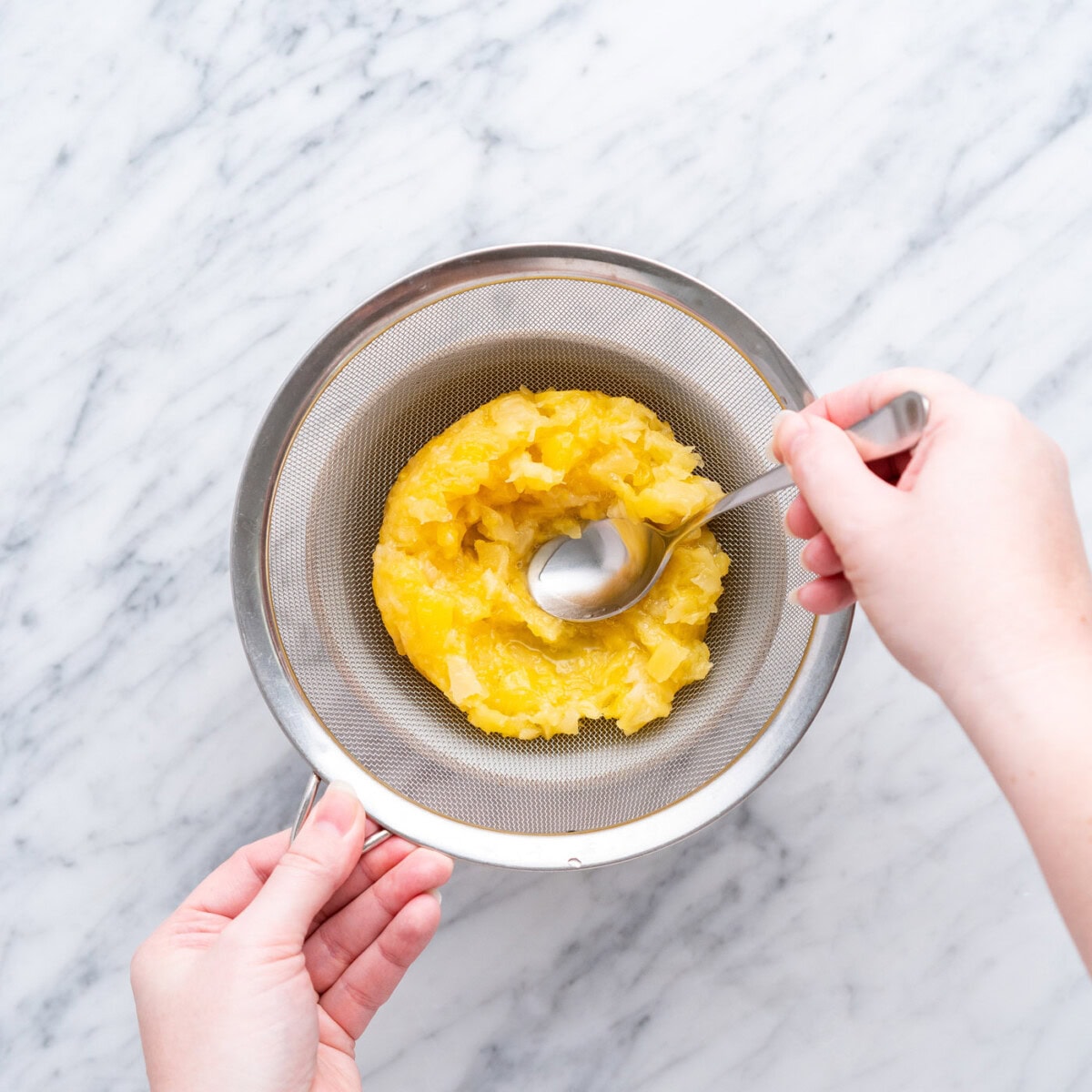 straining crushed pineapple