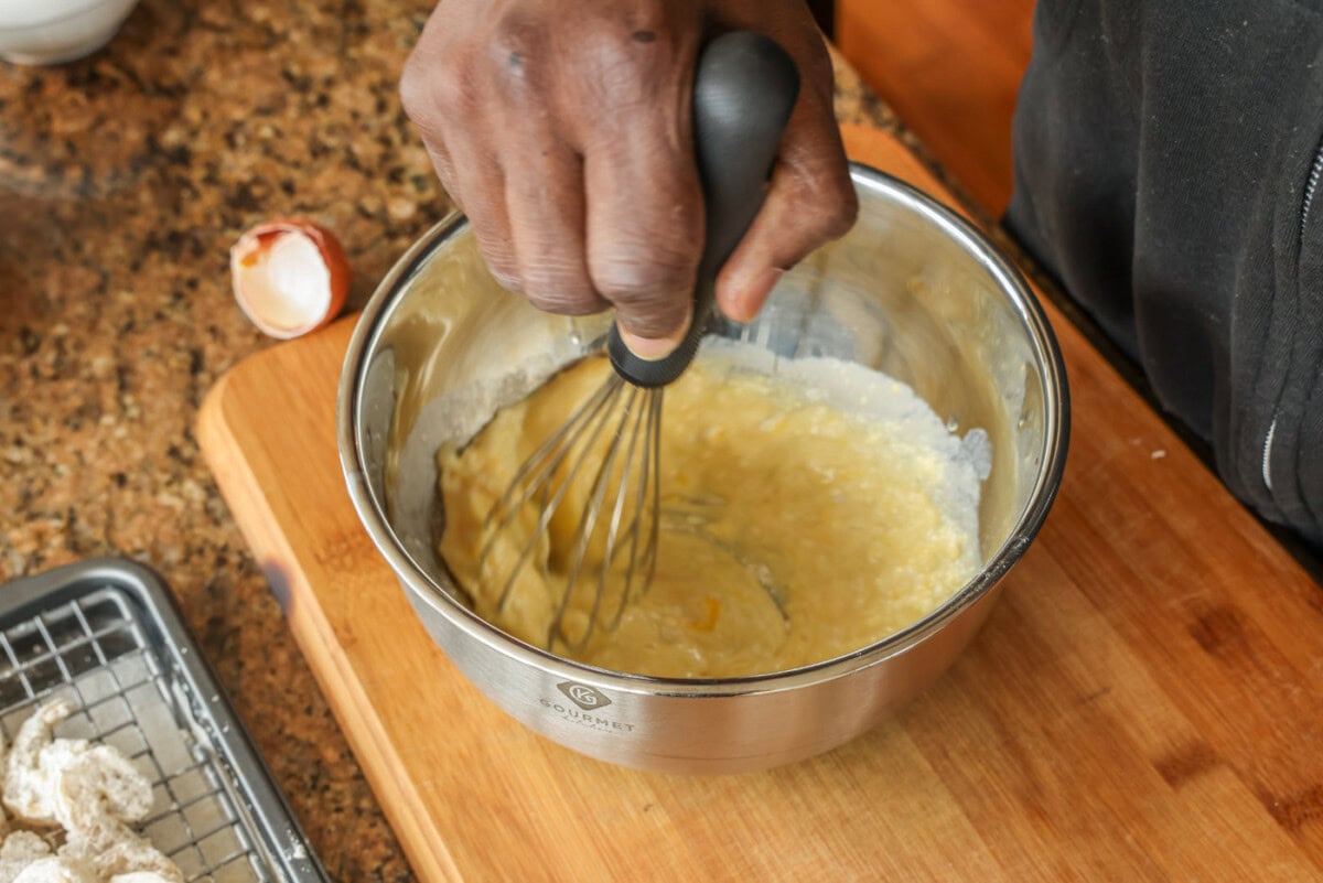 whisking egg milk and flour in a bowl