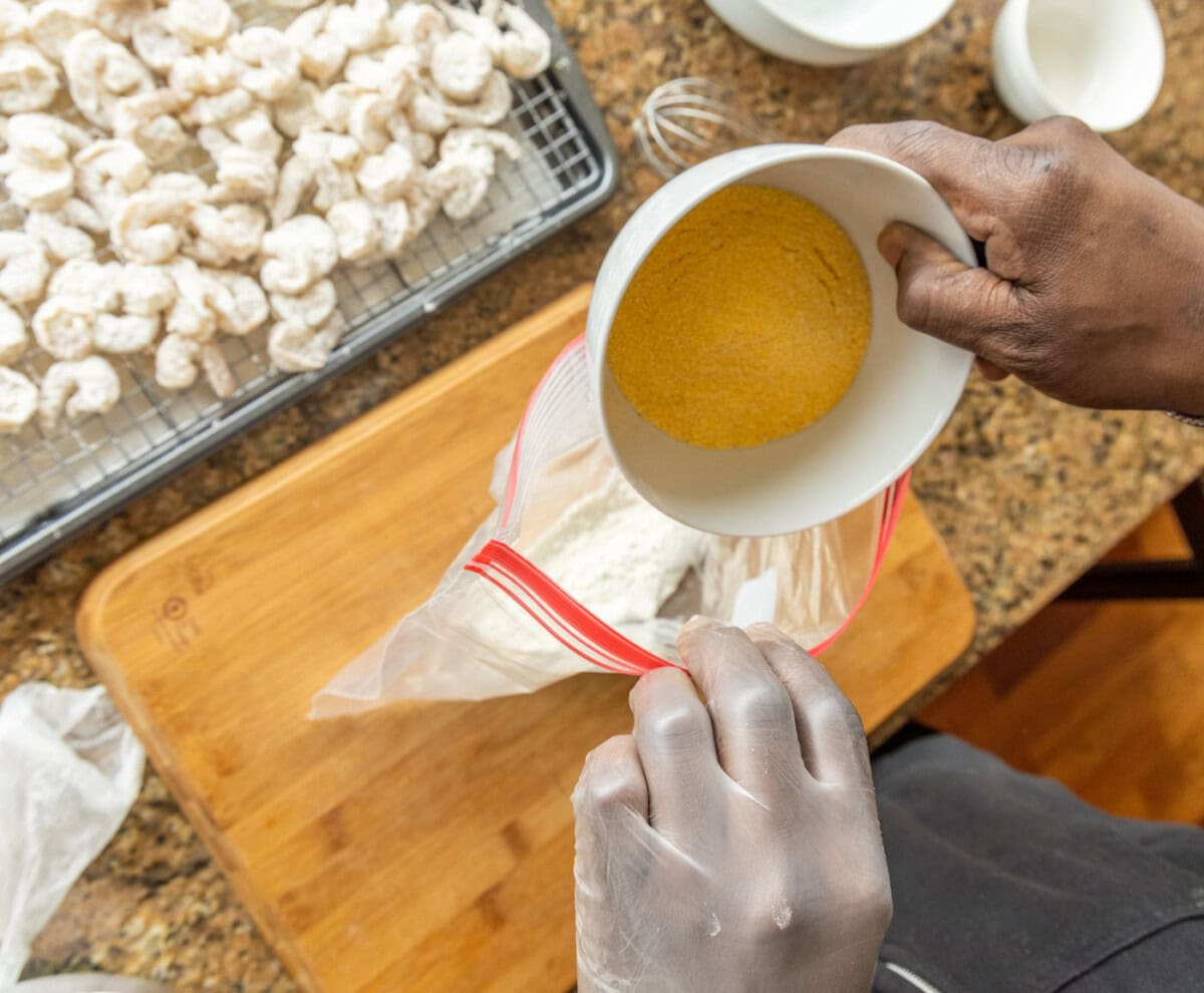 adding cornmeal to a bag of flour