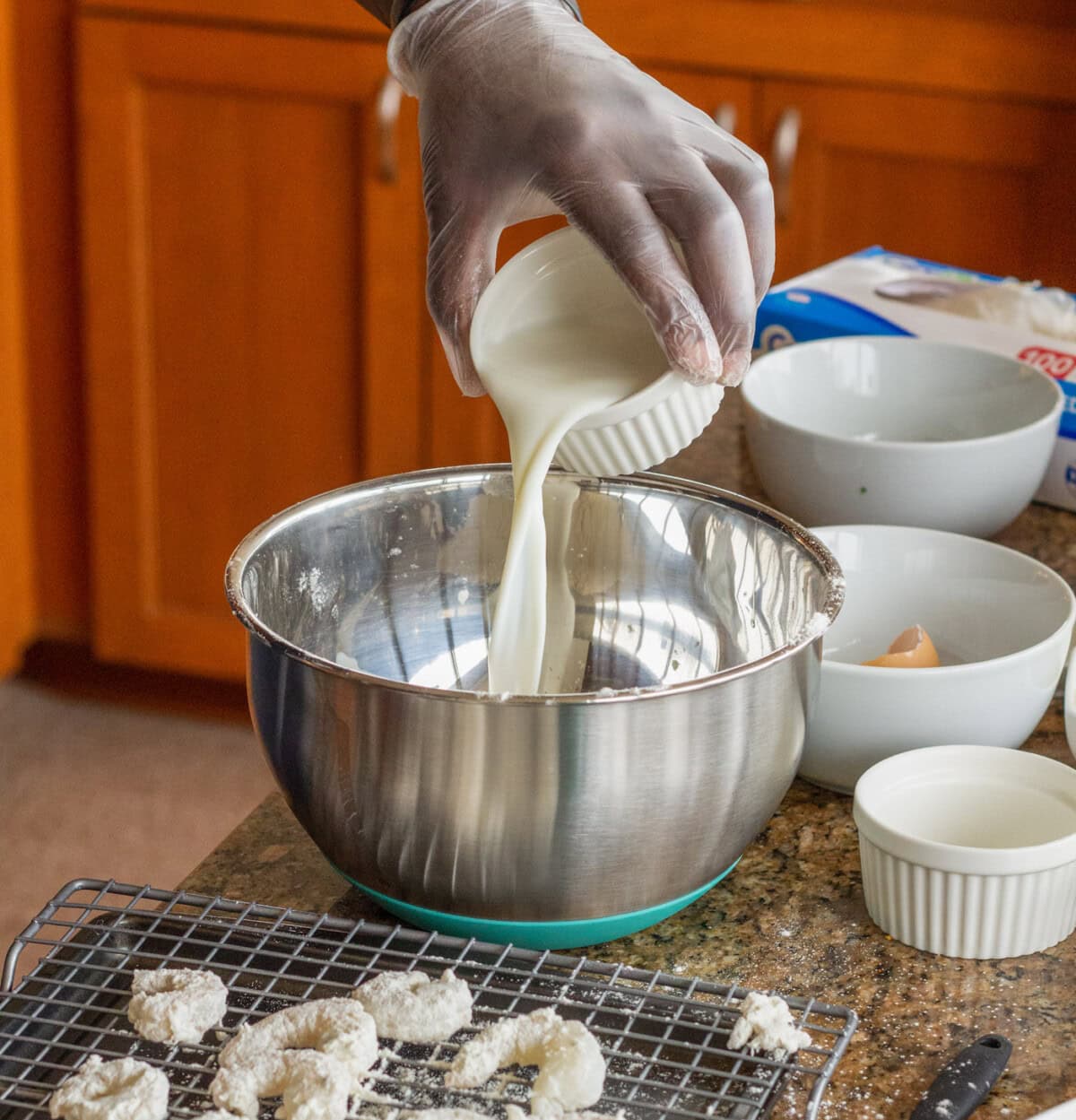 pouring milk into egg mixture for dredging shrimp