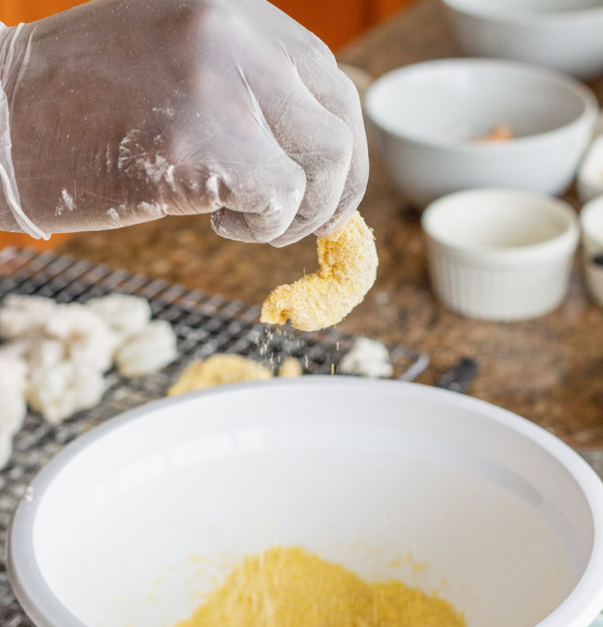 dipping dredged shrimp into cornmeal