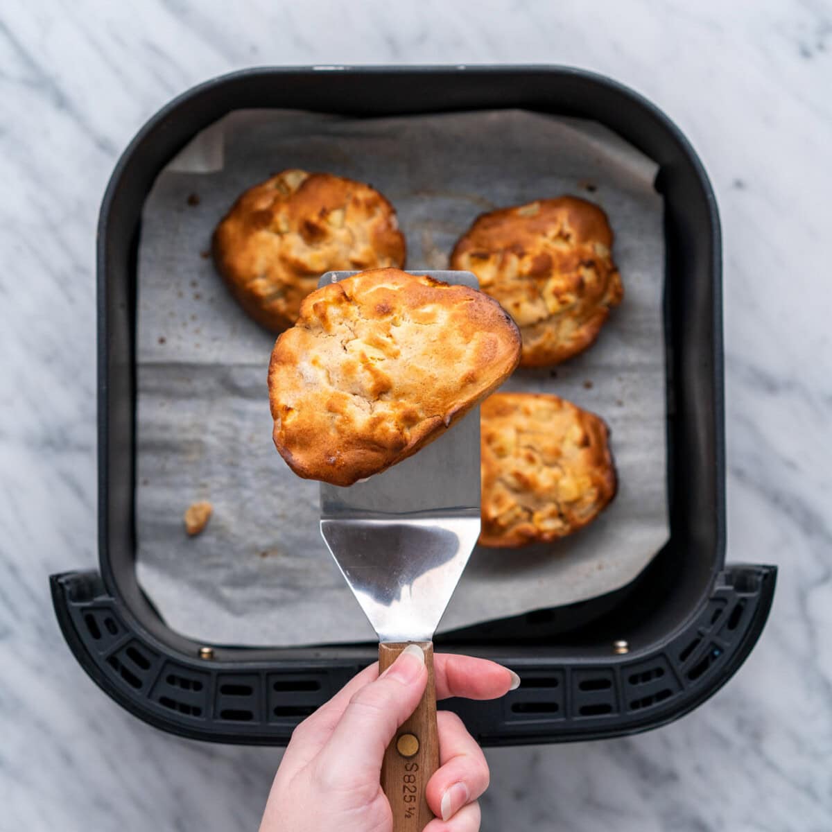 golden air fryer apple fritters on a spatula
