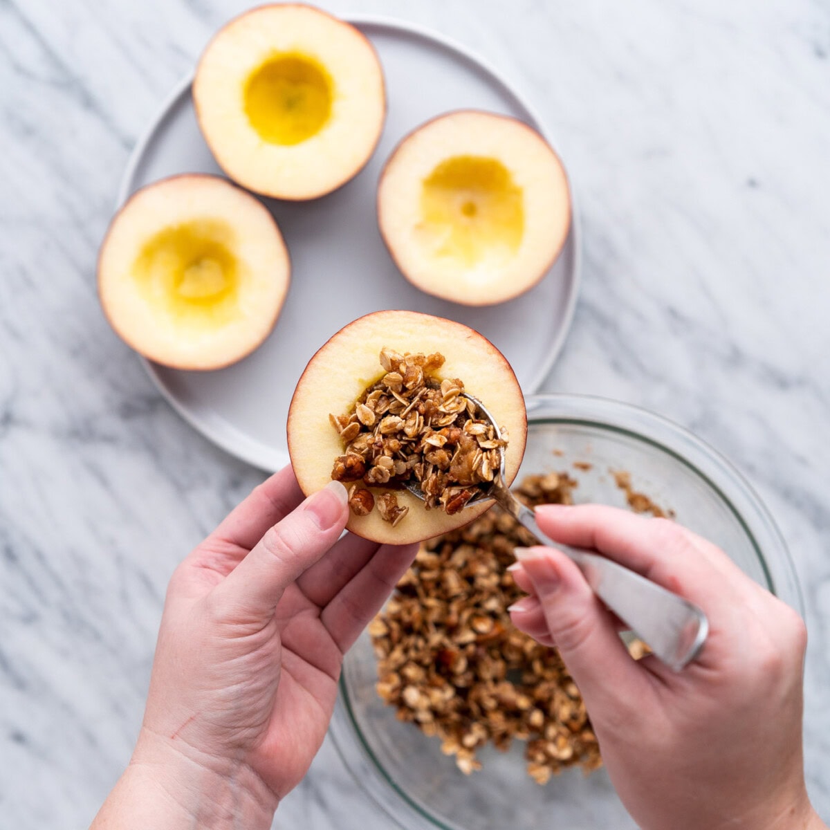 scooping walnut and brown sugar filling into apples