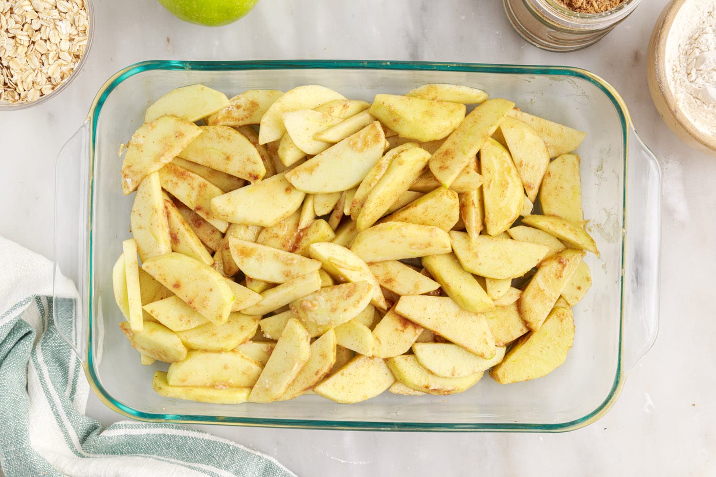 sliced apples with brown sugar and cinnamon in a baking dish