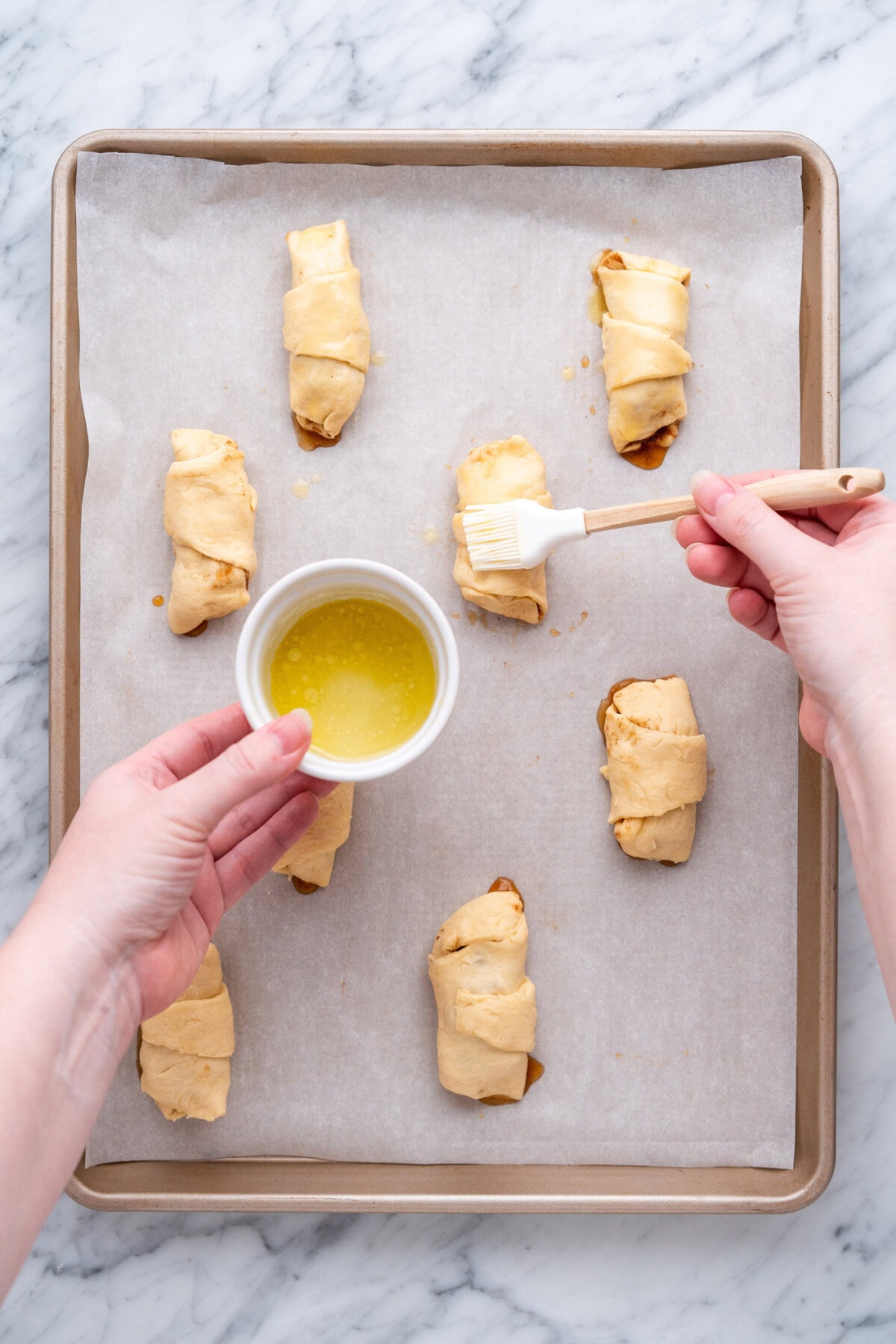 brushing apple pie bites with butter