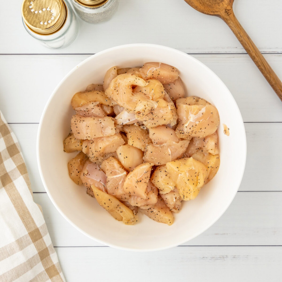 chicken seasoned with salt and pepper in a bowl