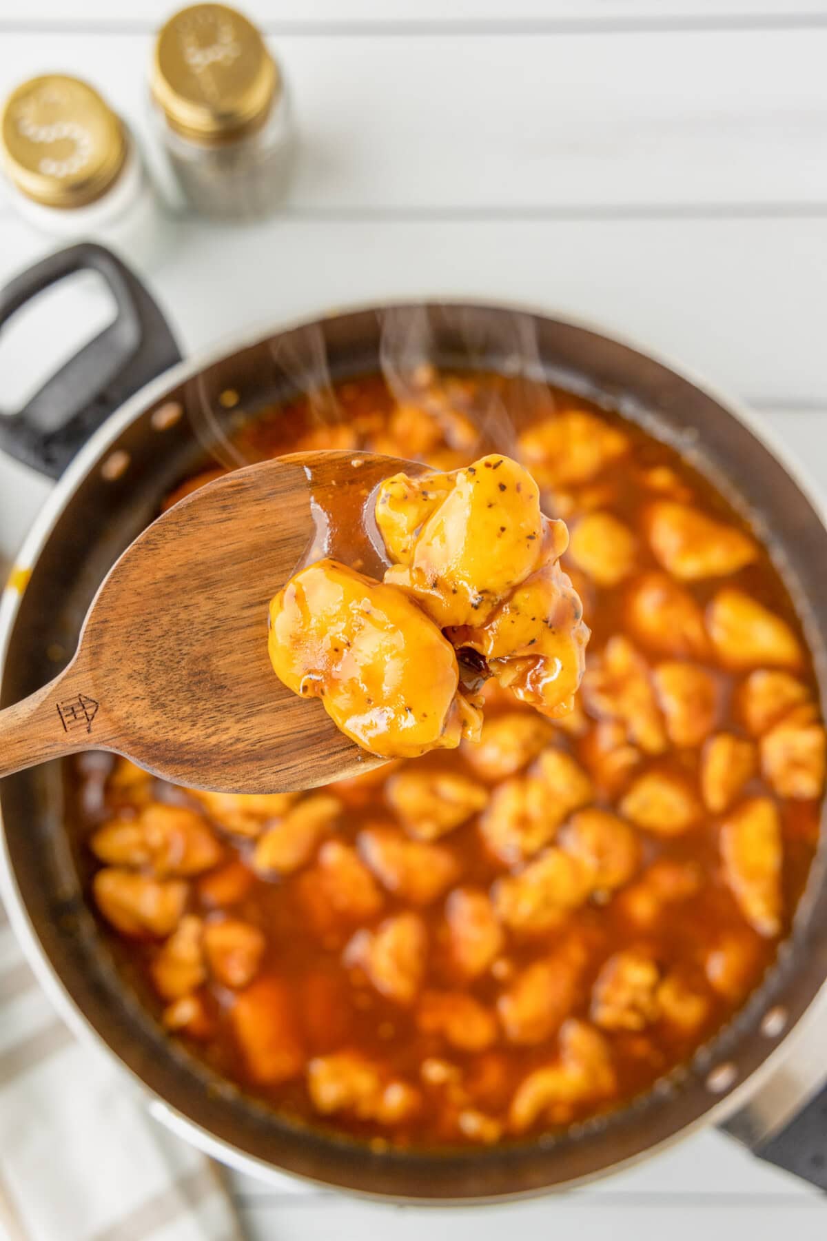 spoon of Bourbon Chicken over skillet