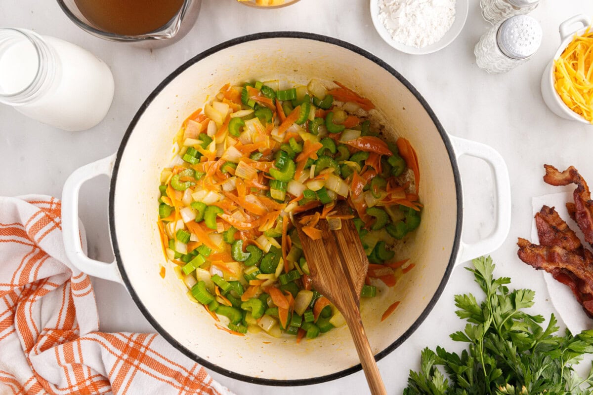 sauteed vegetables in a stockpot with wooden spoon