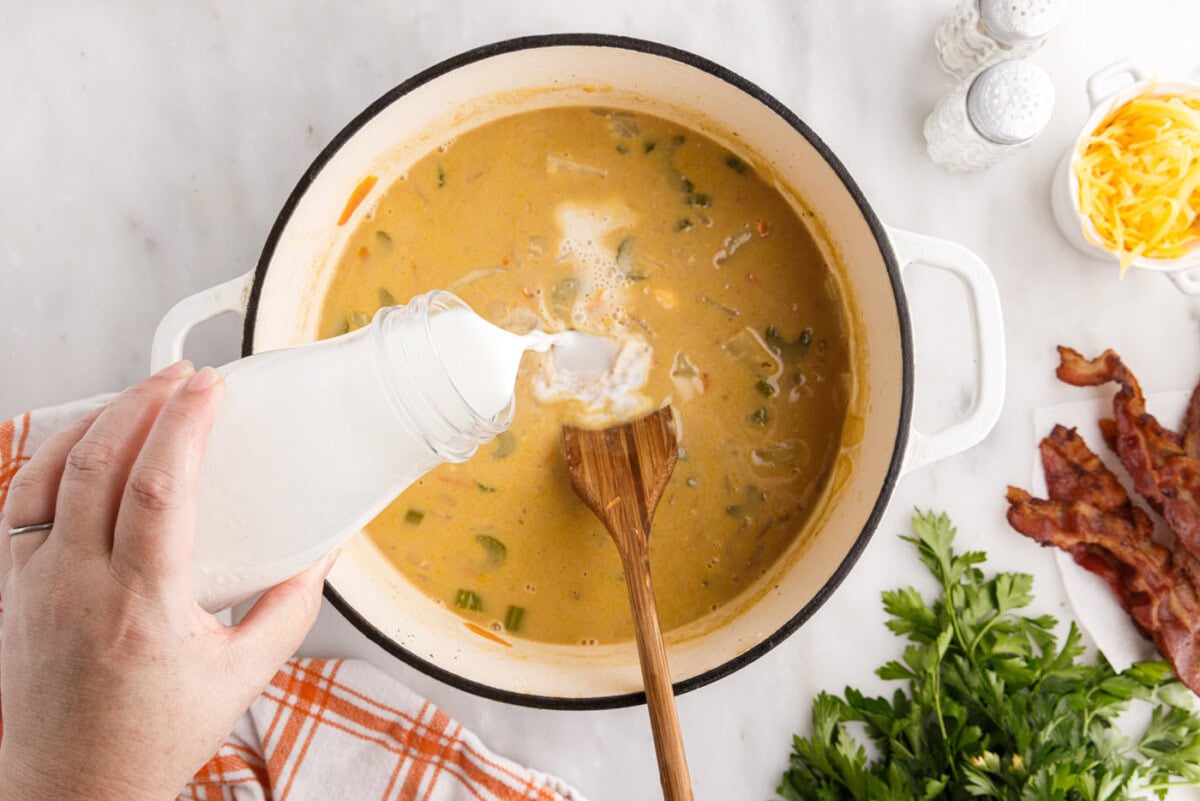 pouring milk into cheeseburger soup