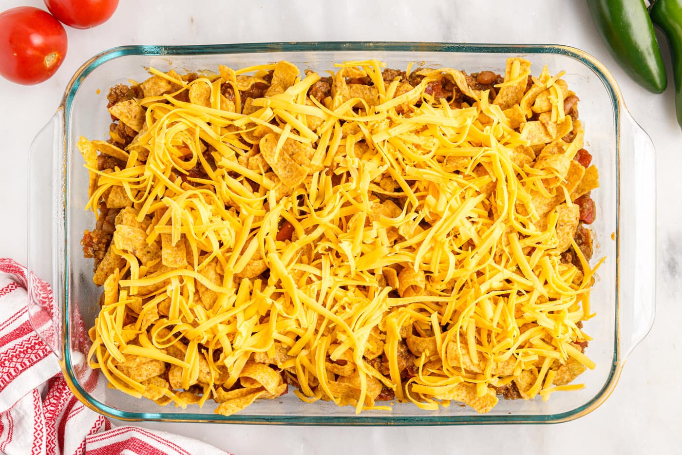 chips and cheese on top of meat mixture in a casserole dish