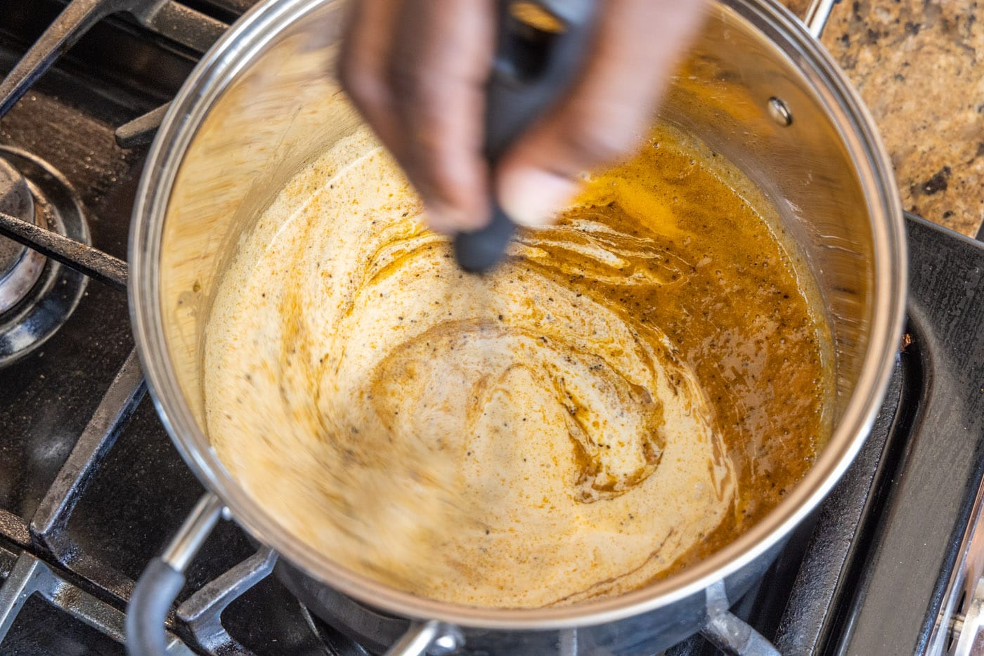 stirring heavy cream and milk into saucepan