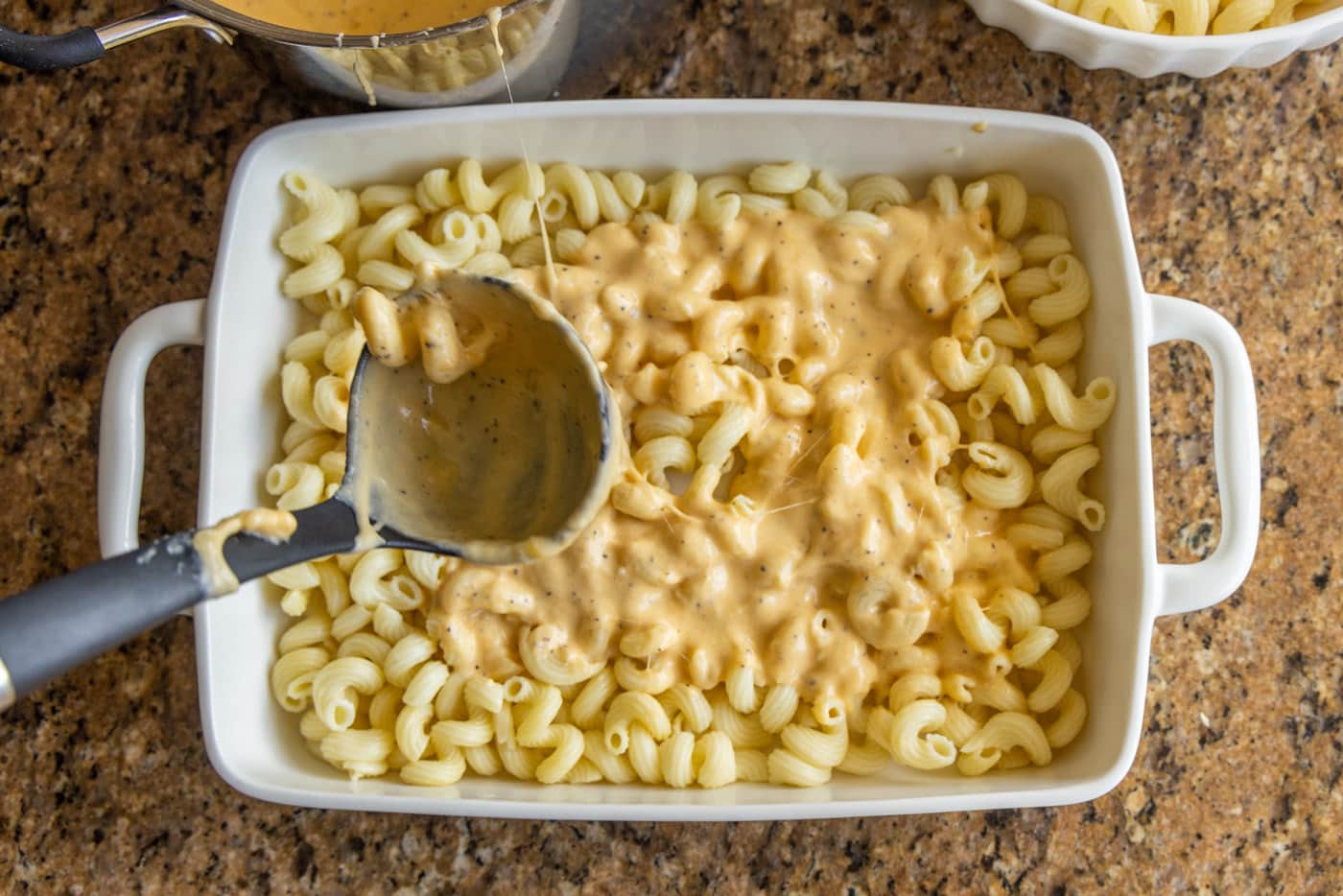 pasta on ladle over mac and cheese