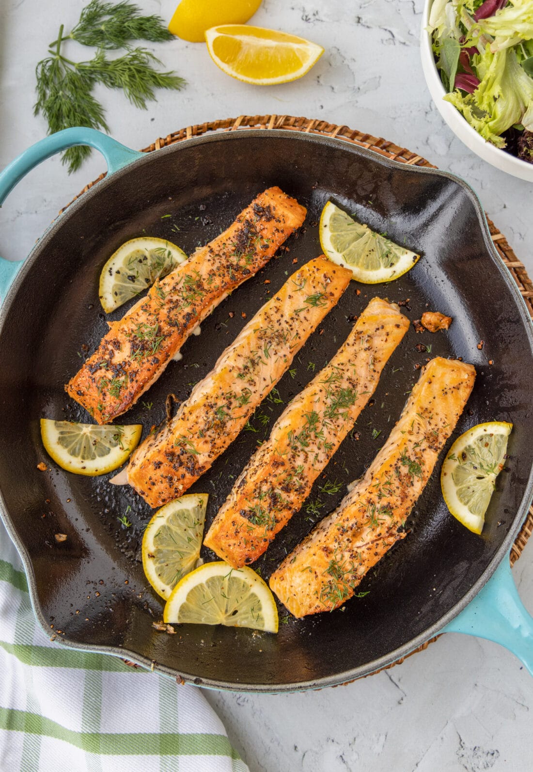 Pan Seared Salmon in a skillet with lemons