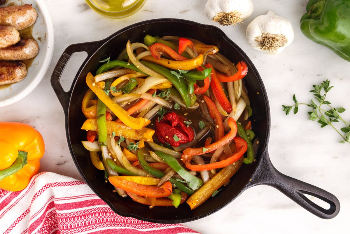tomato paste added to peppers and onions in a skillet