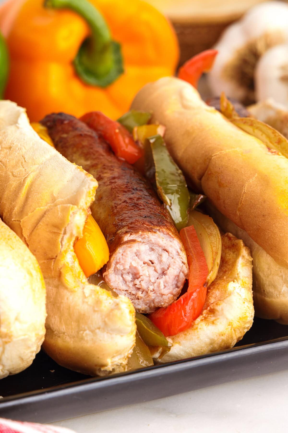 Sausage and Peppers on a bun with a bite out of it