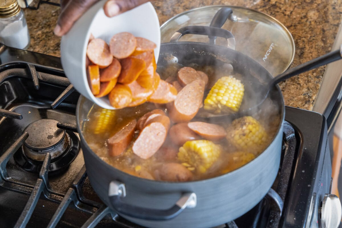 adding sausage to shrimp boil
