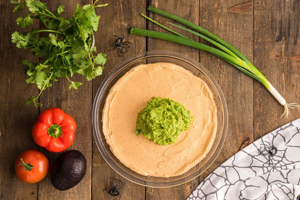 guacamole over the top of sour cream taco dip
