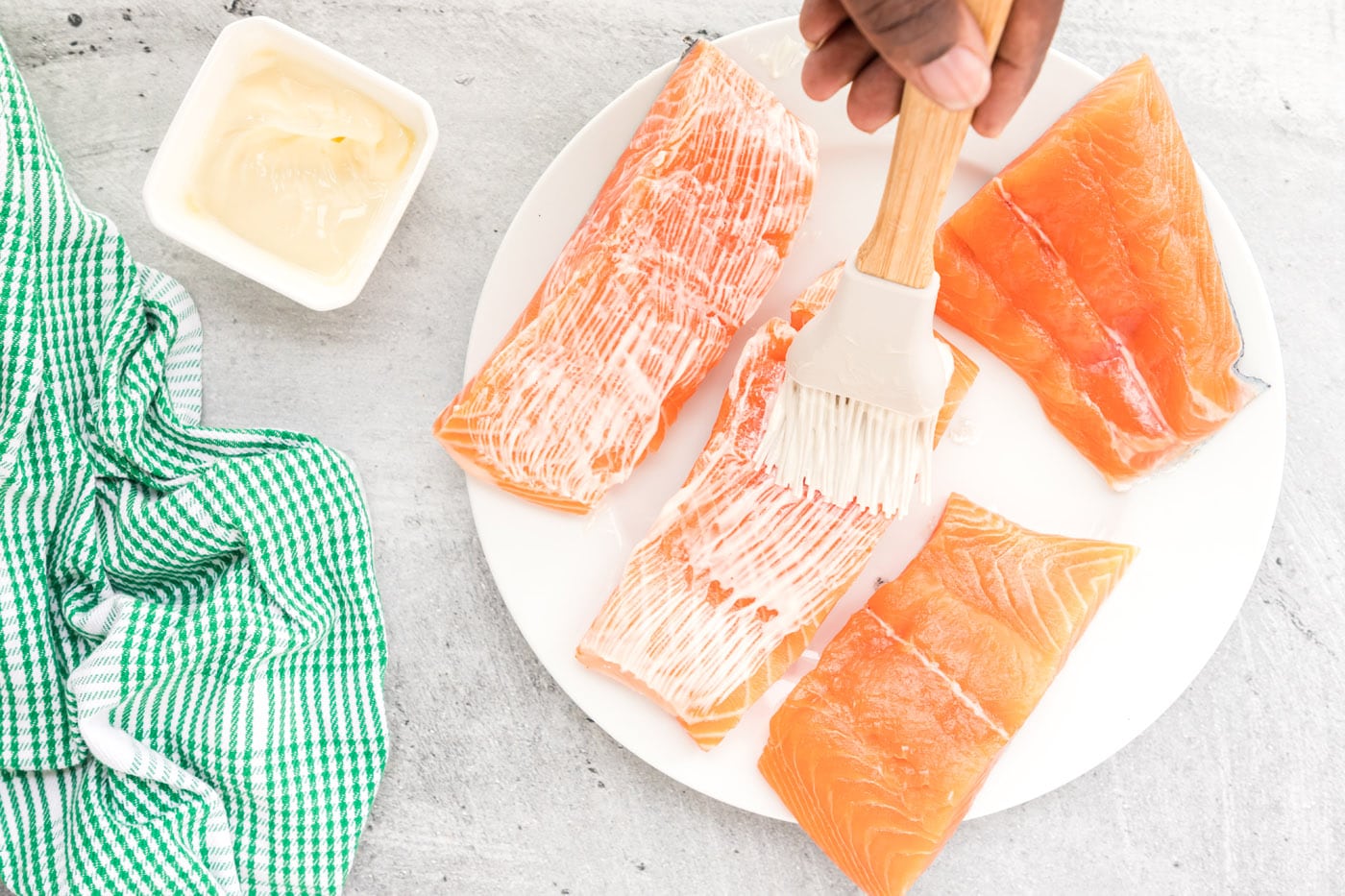 brushing salmon filets with butter