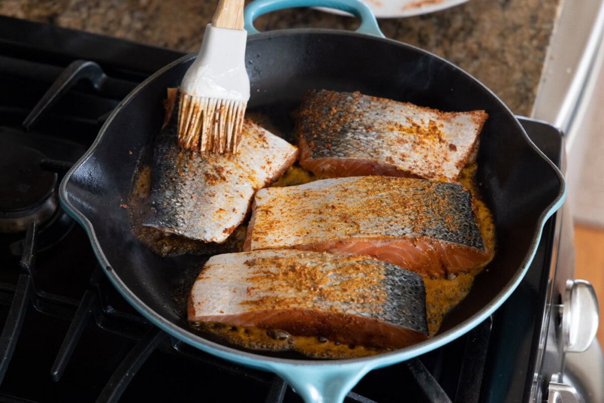 brushing salmon filets with butter
