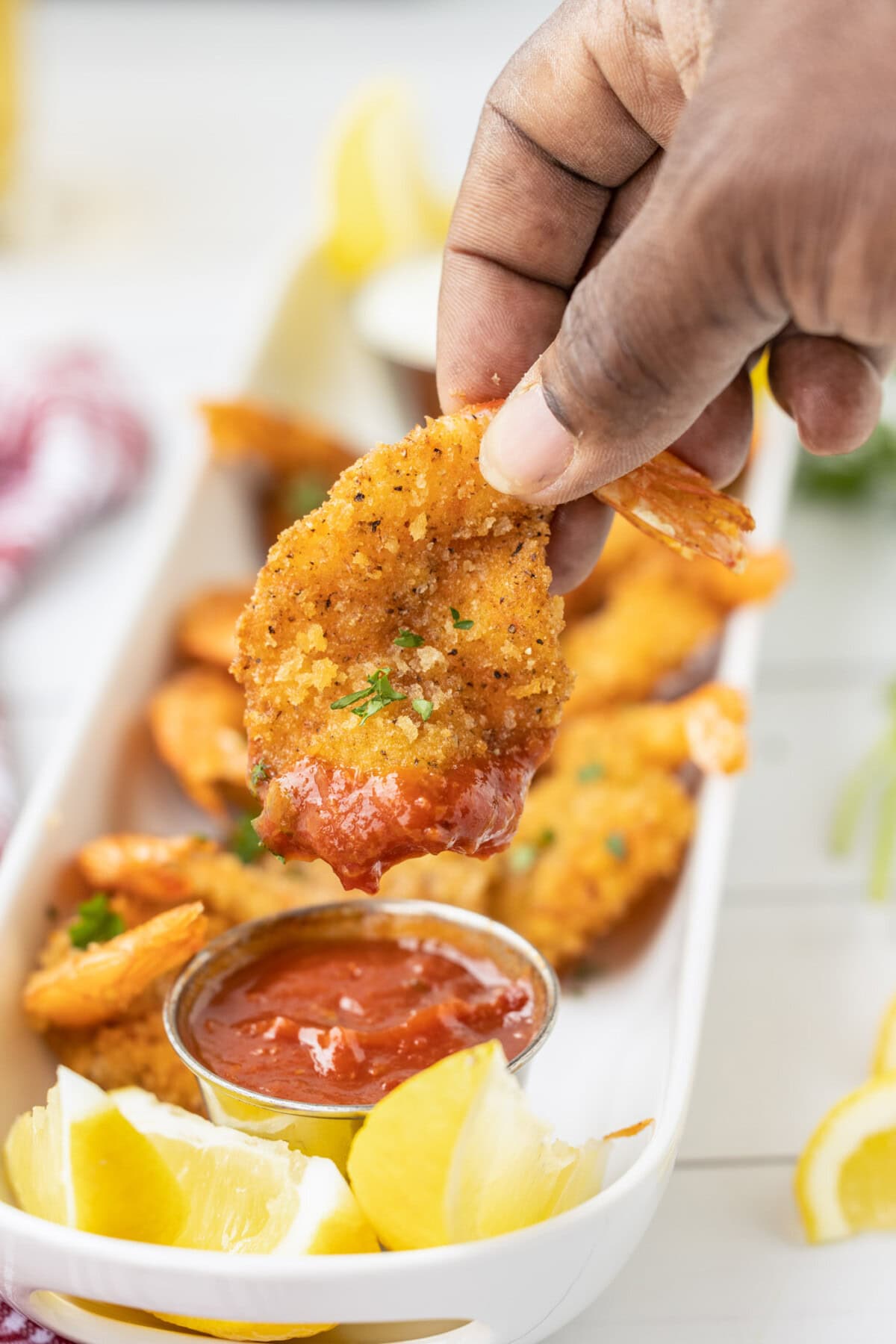 dipping a Butterfly Shrimp in cocktail sauce