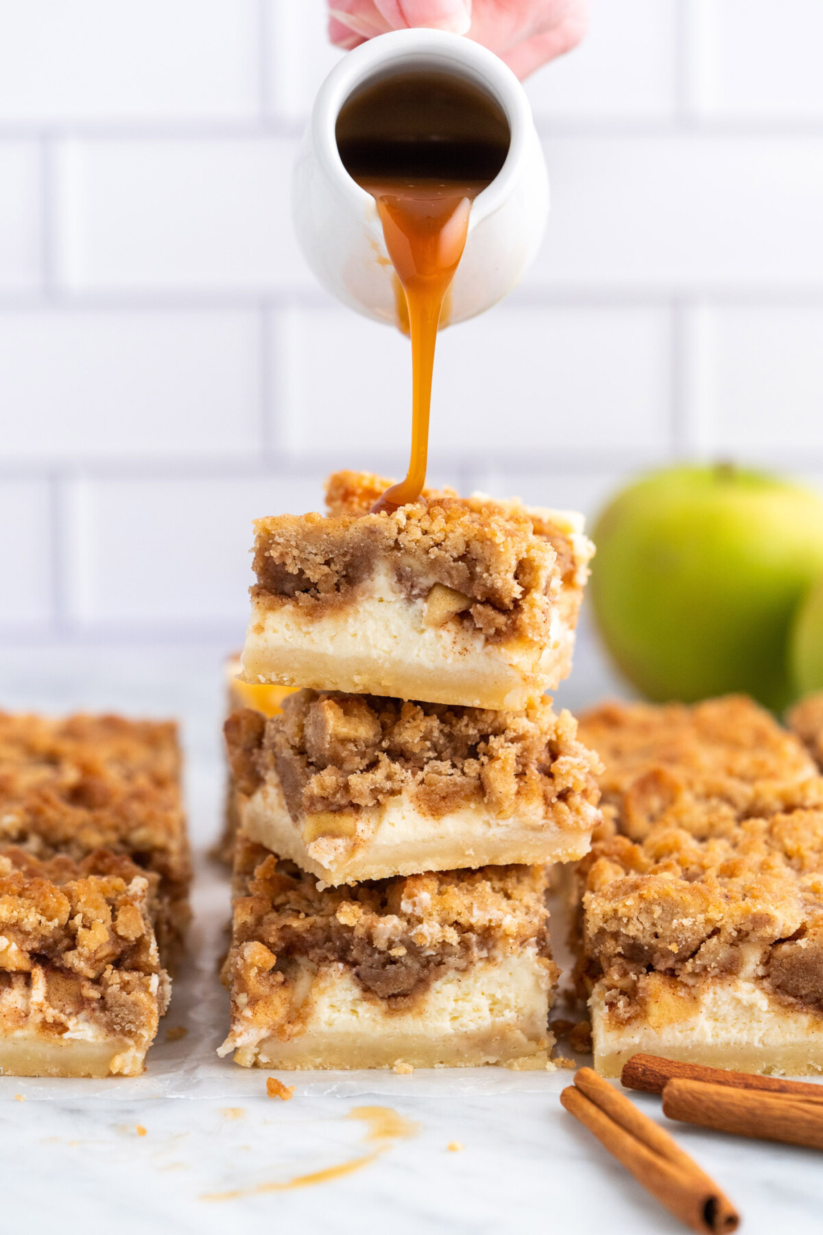 dripping caramel onto Caramel Apple Cheesecake Bars
