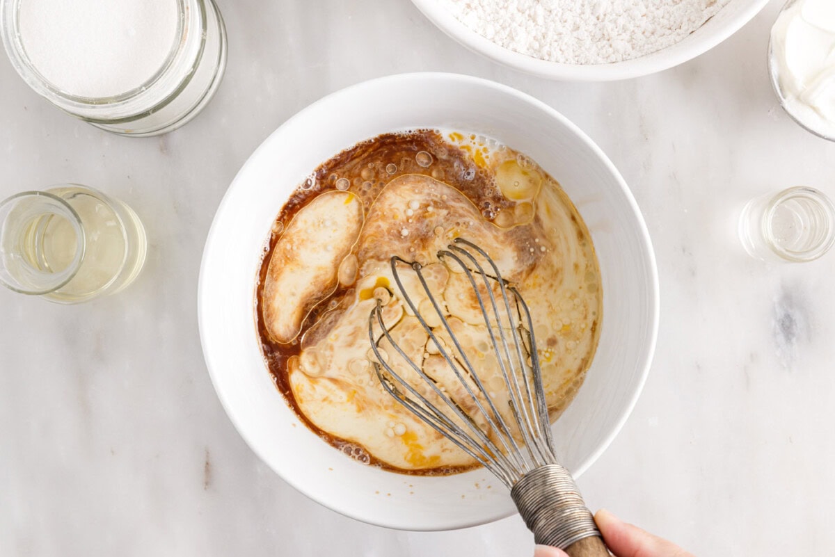eggs, milk, oil, sour cream, and vanilla whisked in a bowl