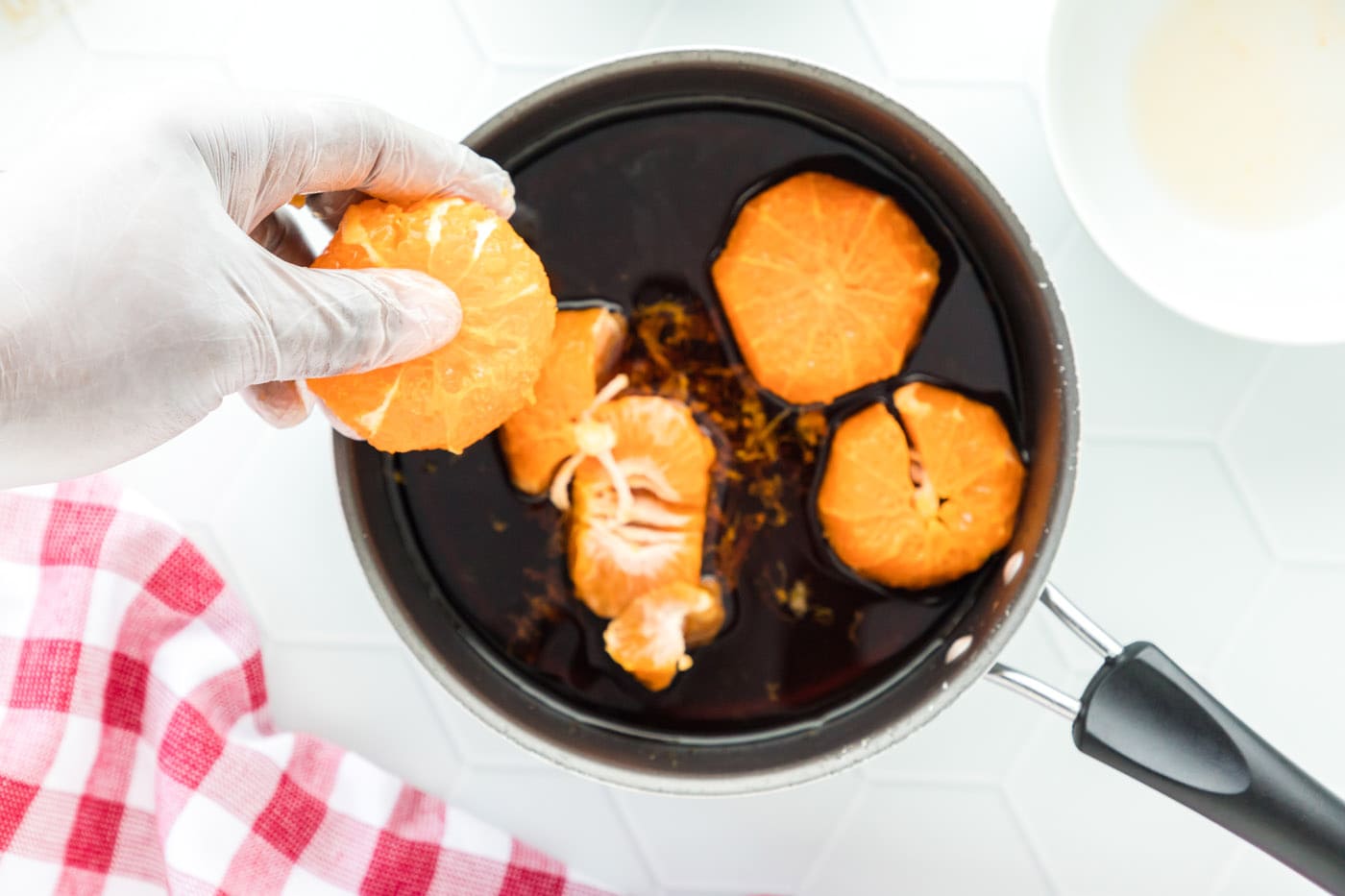 clementines added to sauce in a pan