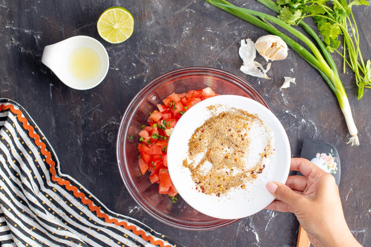 adding seasonings to salsa
