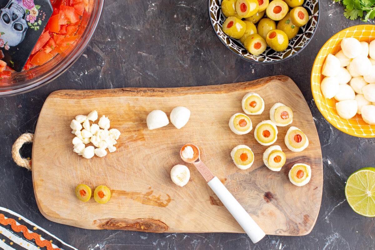 using a 1/4 teaspoon to scoop a hole in a mozzarella ball
